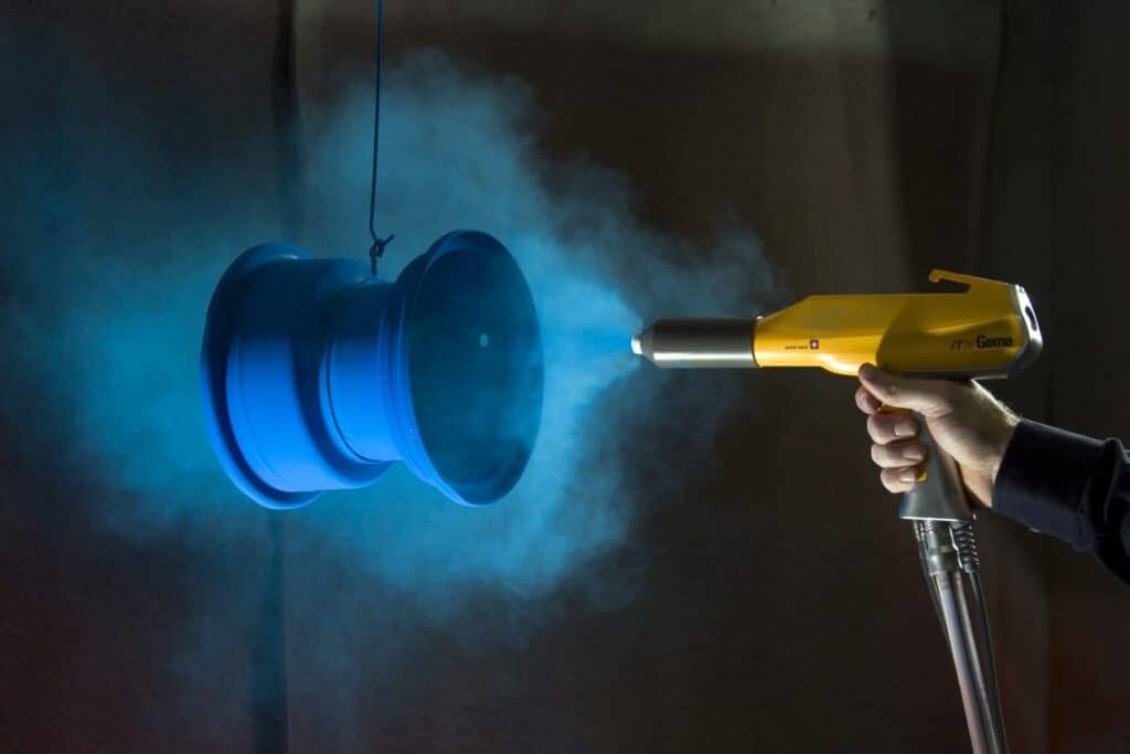 Powder coating is typically applied in a controlled environment like a paint booth.
