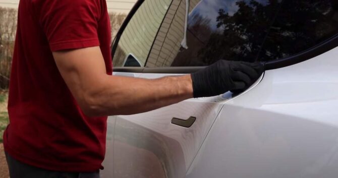 Luke Wilson of Wilson Auto Detailing applies Armor Shield IX ceramic coting to the side of a customer's Tesla Model Y for a YouTube experimental video series. Photo Credit: Wilson Auto Detailing/YouTube
